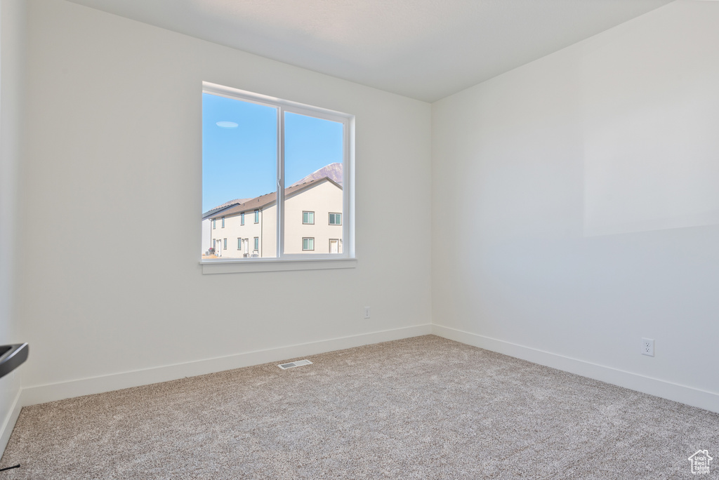 Unfurnished room featuring carpet floors and baseboards
