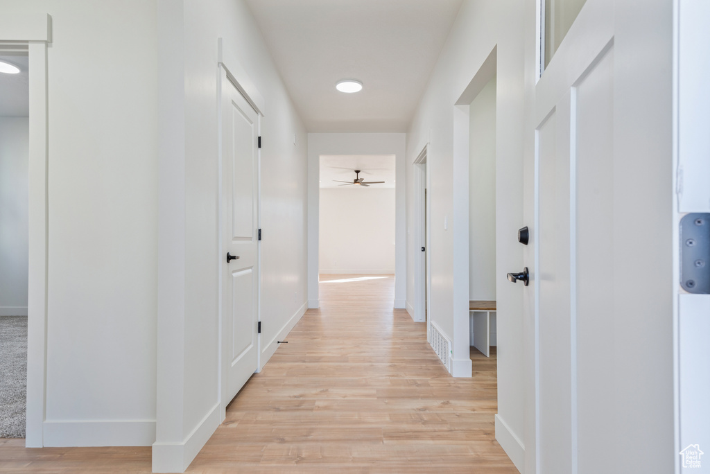 Hall featuring light wood-style flooring and baseboards