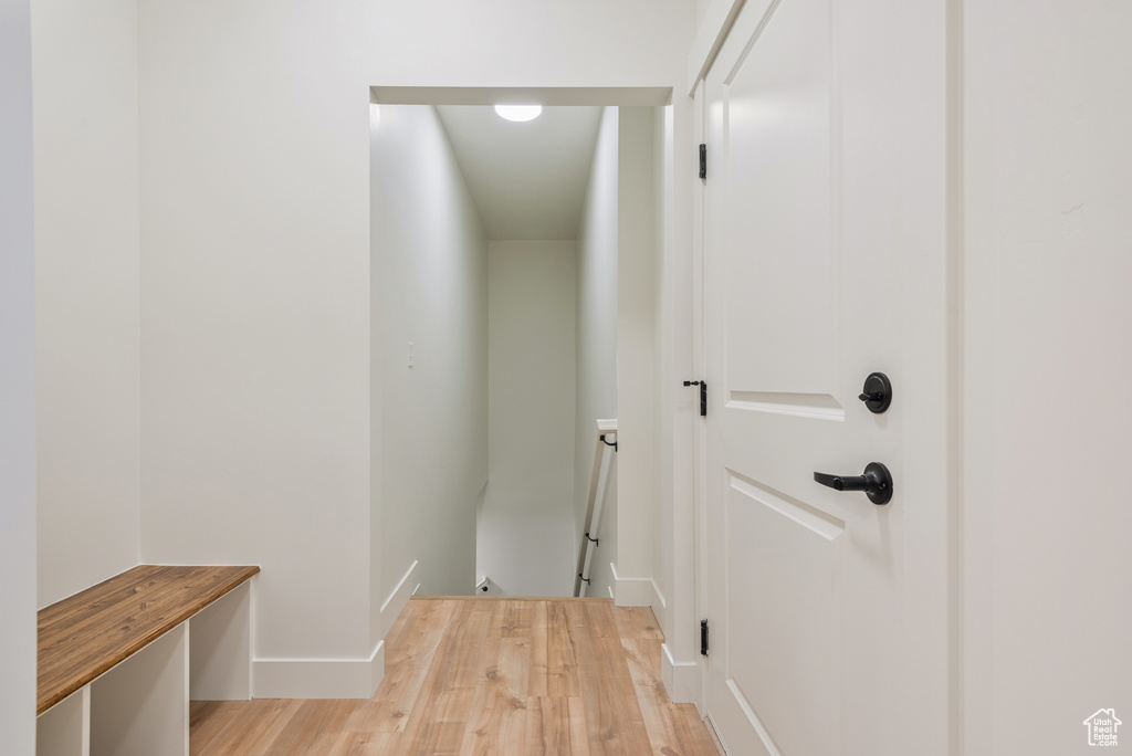 Hall featuring an upstairs landing, light wood-style floors, and baseboards