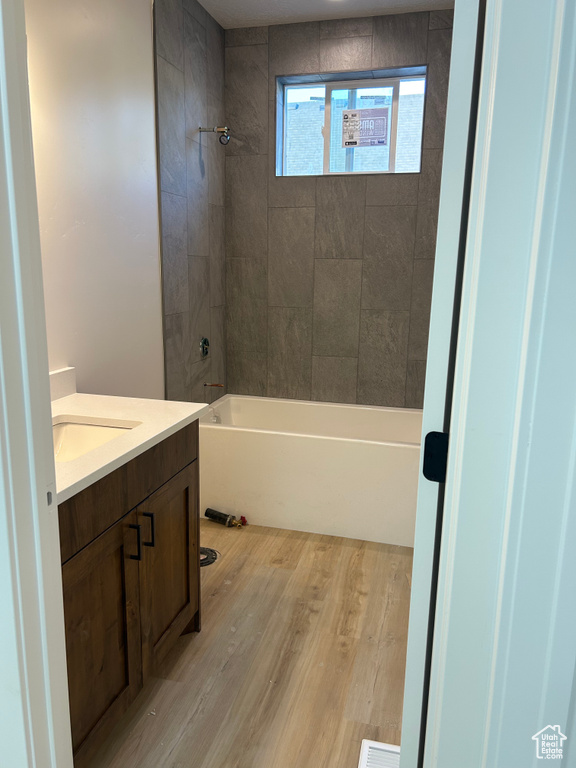 Bathroom with vanity, tub / shower combination, and wood finished floors