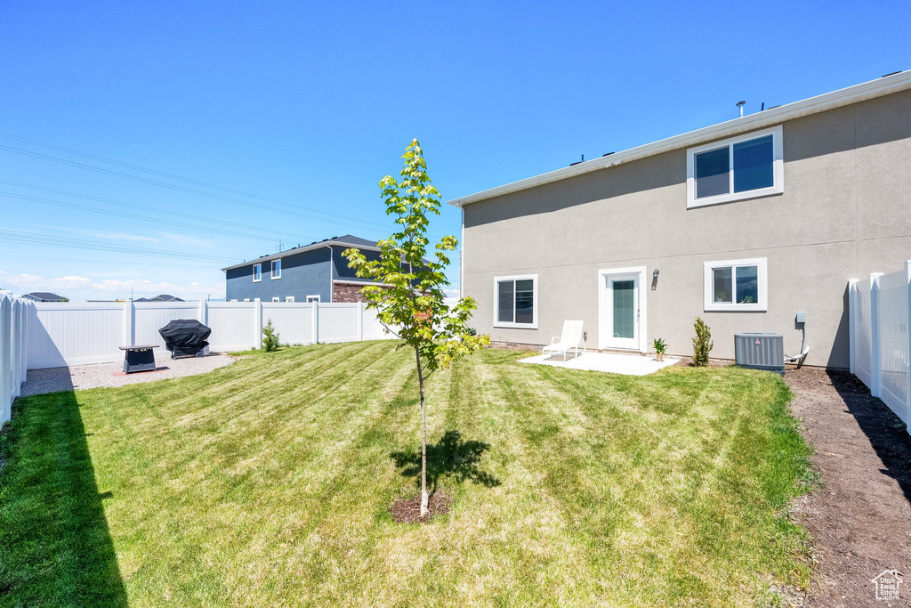 Rear view of house with central AC unit, stucco siding, and a patio