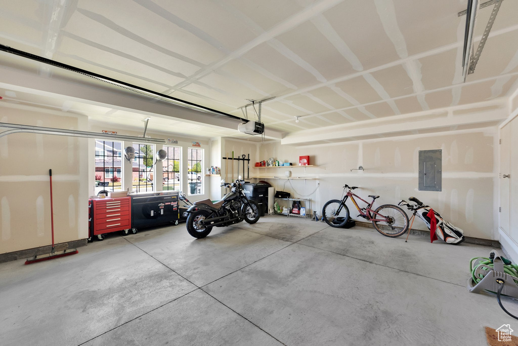 Garage featuring electric panel and a garage door opener