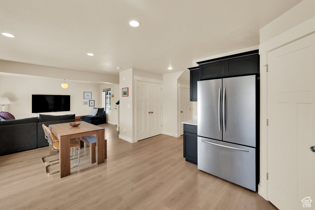 Kitchen featuring freestanding refrigerator, open floor plan, recessed lighting, light wood-style floors, and light countertops
