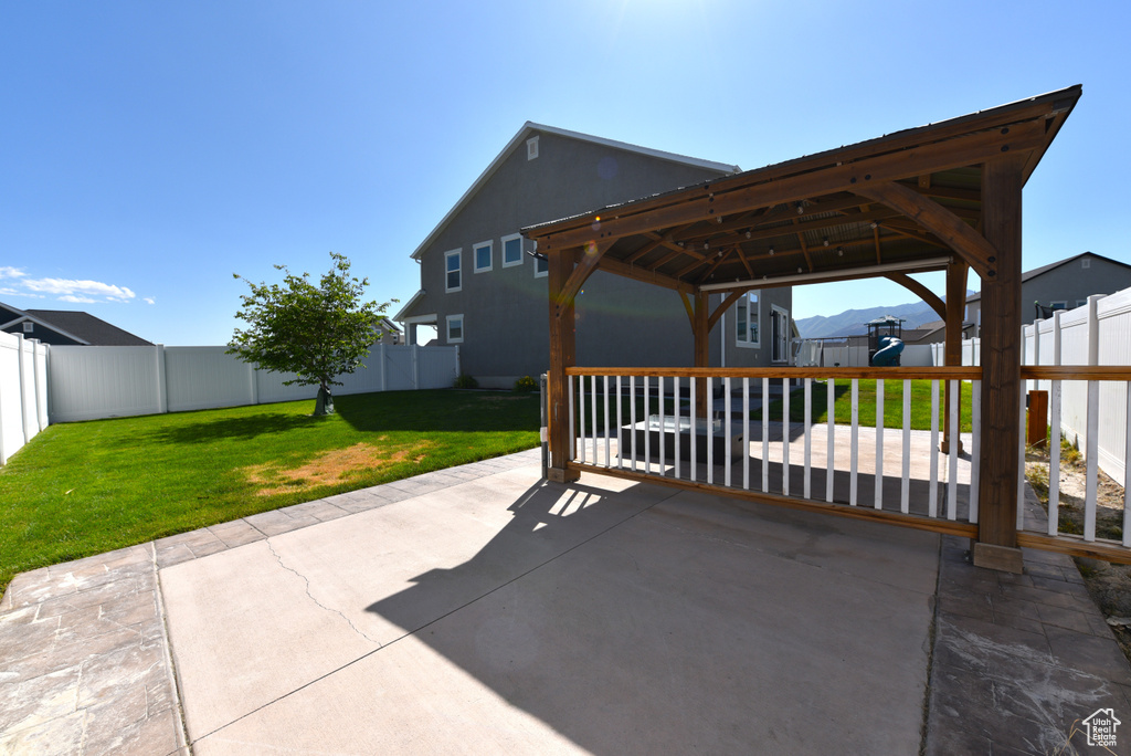Fenced backyard featuring a patio area and a gazebo