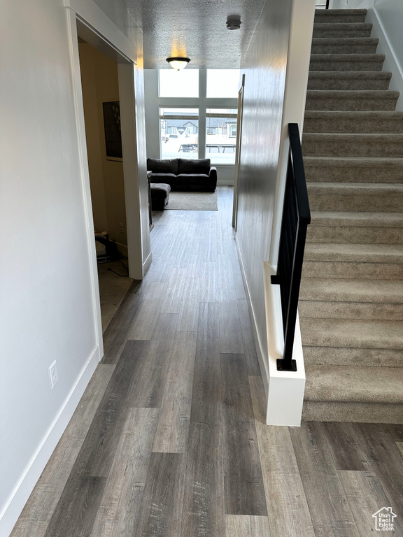 Staircase featuring wood finished floors and baseboards