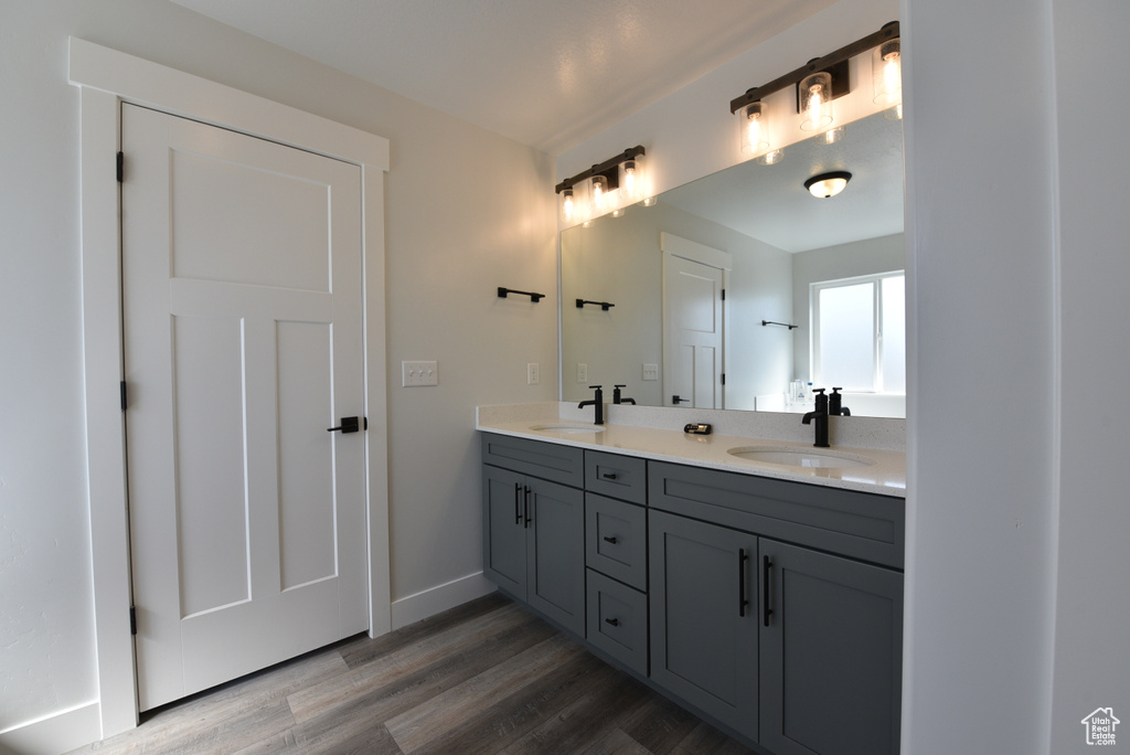 Bathroom with double vanity and wood finished floors