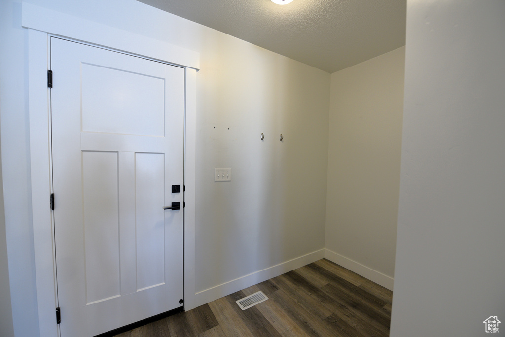 Doorway with dark wood-style floors and a textured ceiling