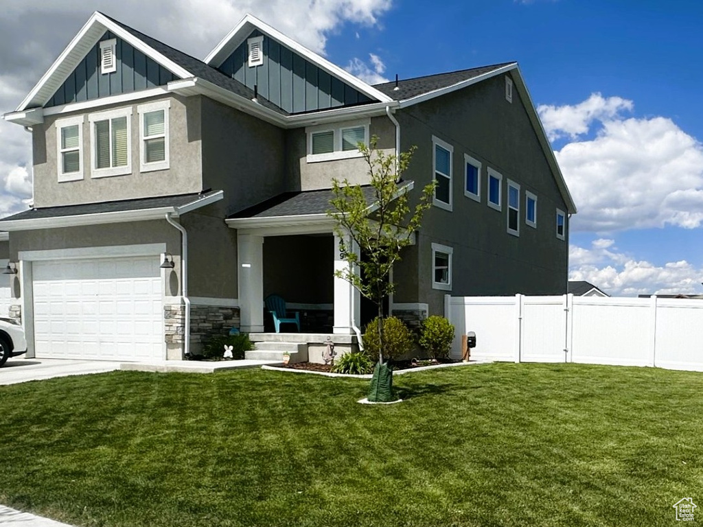 Craftsman inspired home featuring an attached garage, board and batten siding, stucco siding, driveway, and stone siding