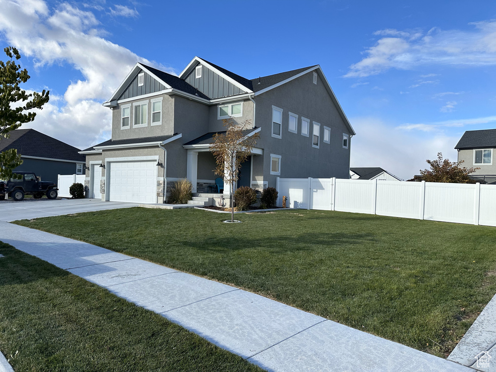 View of front facade featuring a garage, board and batten siding, concrete driveway, and stucco siding