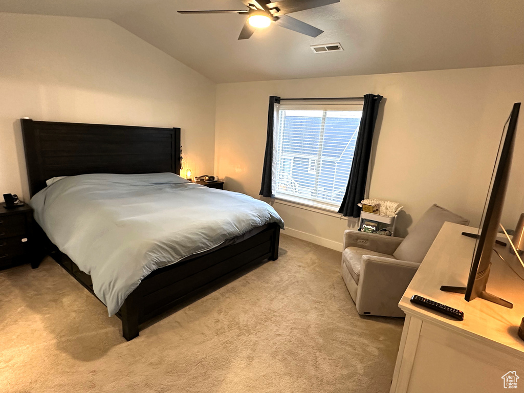 Bedroom featuring light carpet, vaulted ceiling, ceiling fan, and baseboards
