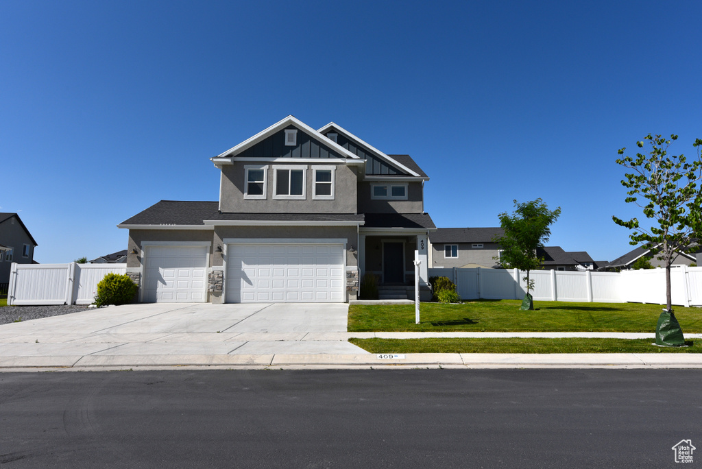 View of front of home featuring driveway, an attached garage, stucco siding, and stone siding