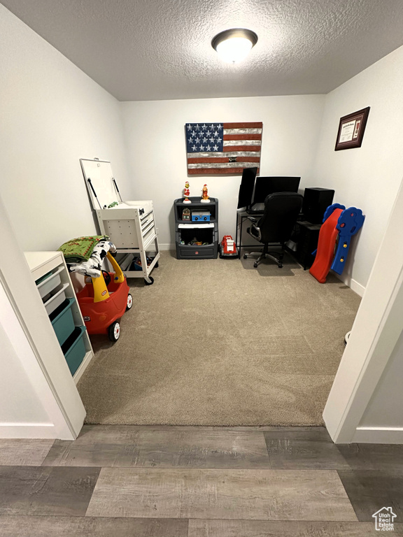 Office space with a textured ceiling and wood finished floors