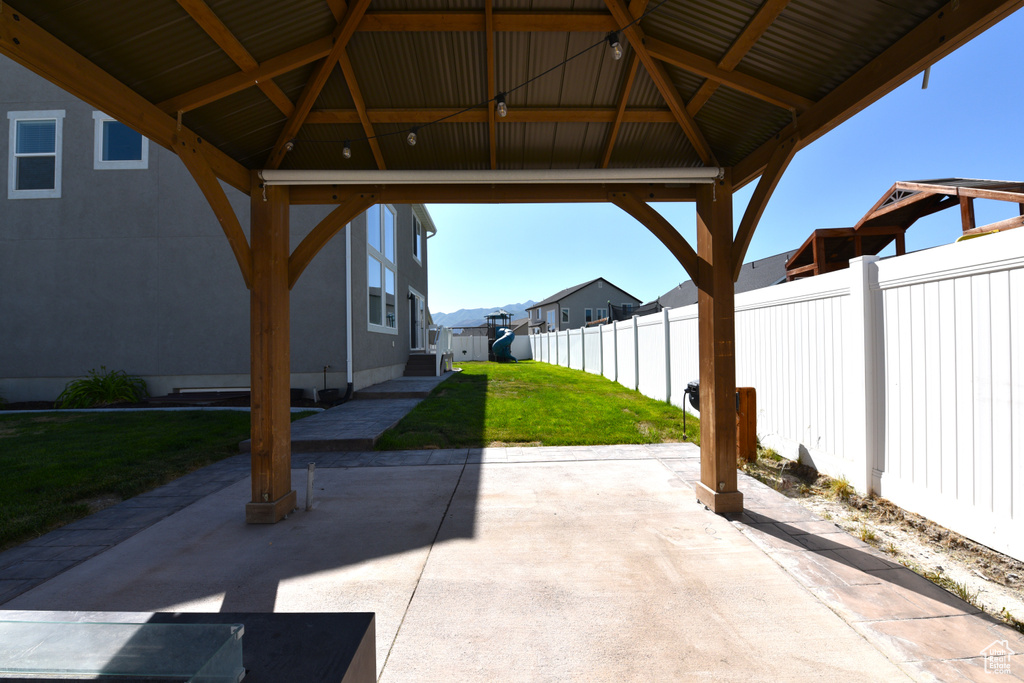 Fenced backyard with a gazebo, a patio, and a residential view