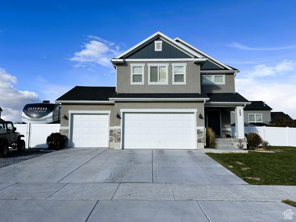 View of front of house featuring concrete driveway, stucco siding, a garage, and stone siding