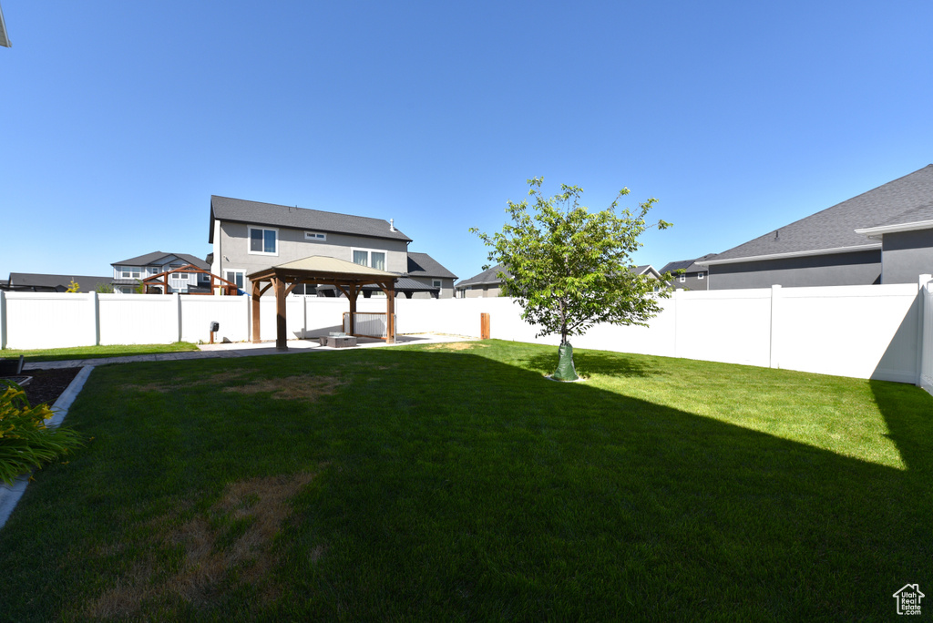 Fenced backyard featuring a gazebo and a patio