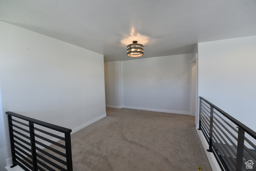 Empty room featuring carpet flooring and baseboards