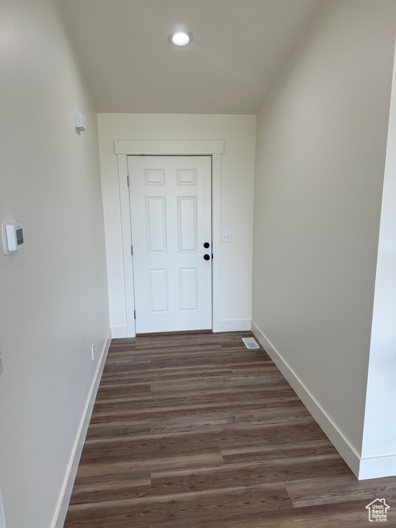 Doorway featuring baseboards, recessed lighting, and dark wood-style flooring