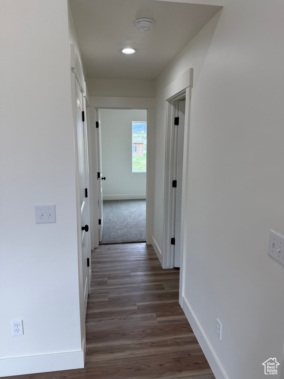 Hallway with baseboards, dark wood-style floors, and recessed lighting