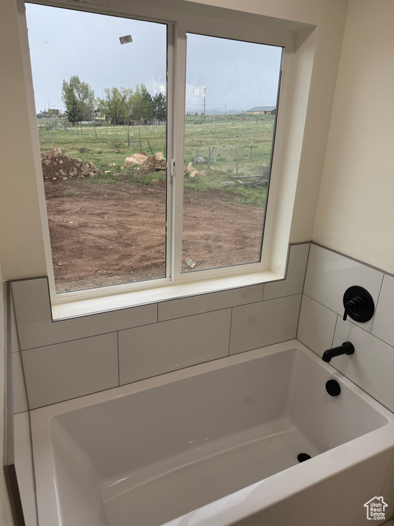 Bathroom with plenty of natural light, a bath, and a view of rural / pastoral area