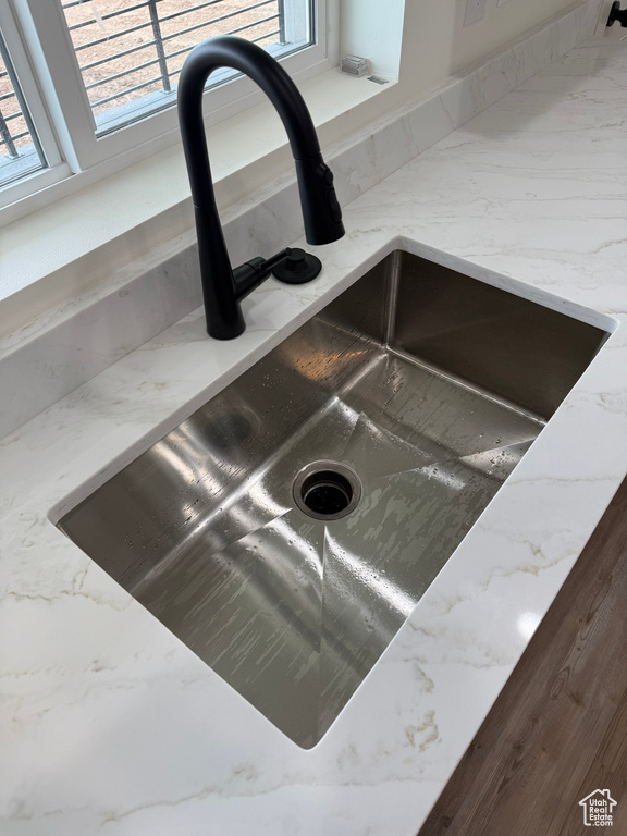 Kitchen view of a sink and light stone counters