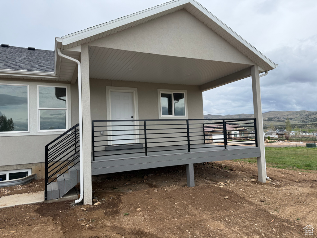 View of exterior entry featuring stucco siding and a mountain view