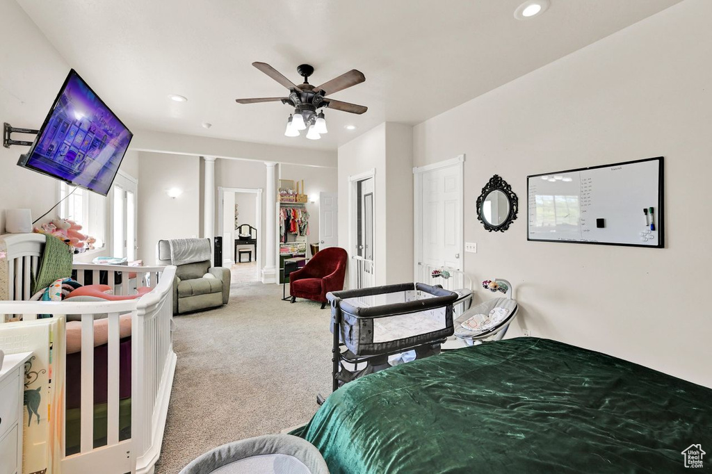 Carpeted bedroom with recessed lighting, ceiling fan, and ornate columns