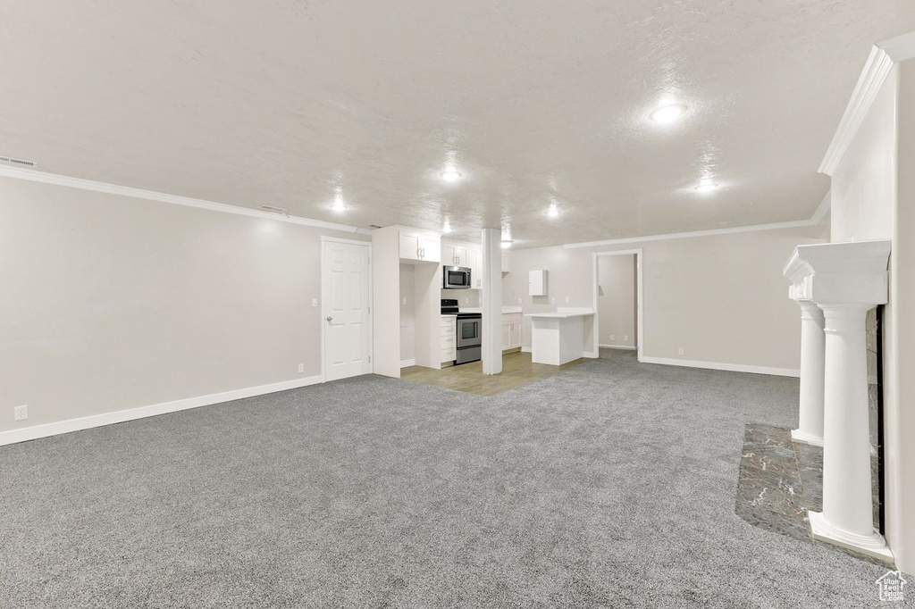 Finished basement featuring light colored carpet, crown molding, and baseboards