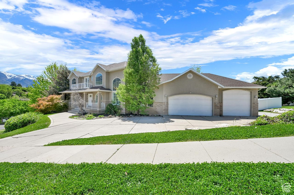 View of front of house featuring driveway, a garage, stucco siding, and a porch