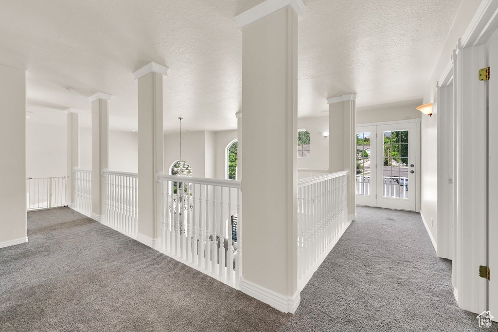 Hall with carpet flooring and a textured ceiling