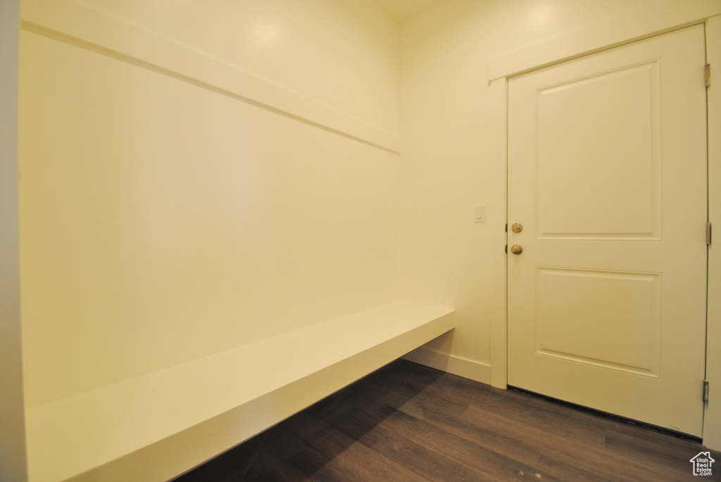 Mudroom with dark wood finished floors and baseboards