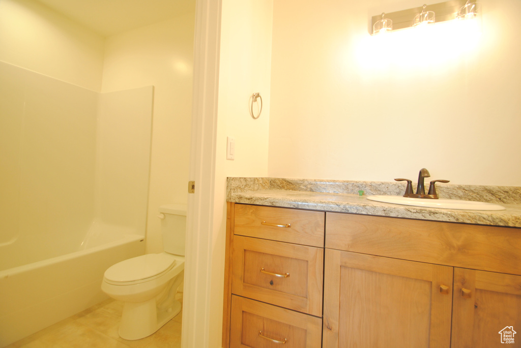 Full bathroom with toilet, tile patterned flooring, vanity, and shower / tub combination