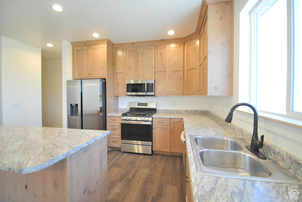 Kitchen featuring stainless steel appliances, a sink, light brown cabinets, dark wood-style flooring, and recessed lighting