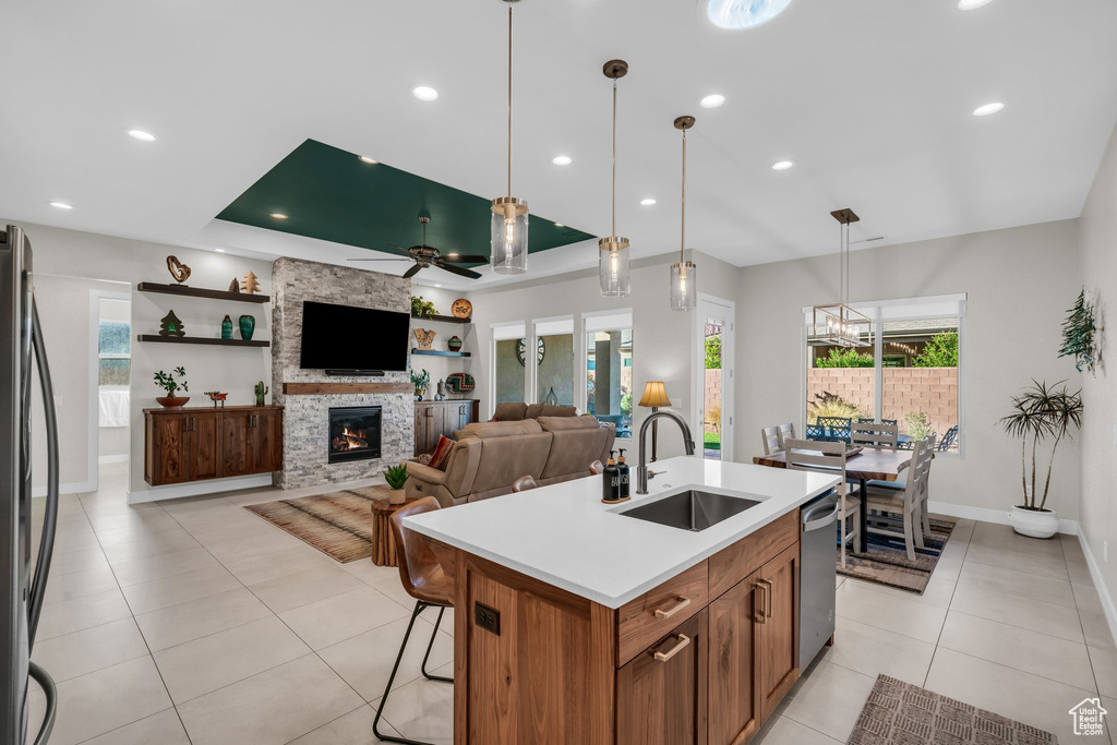 Kitchen featuring a sink, stainless steel dishwasher, freestanding refrigerator, light tile patterned flooring, and ceiling fan