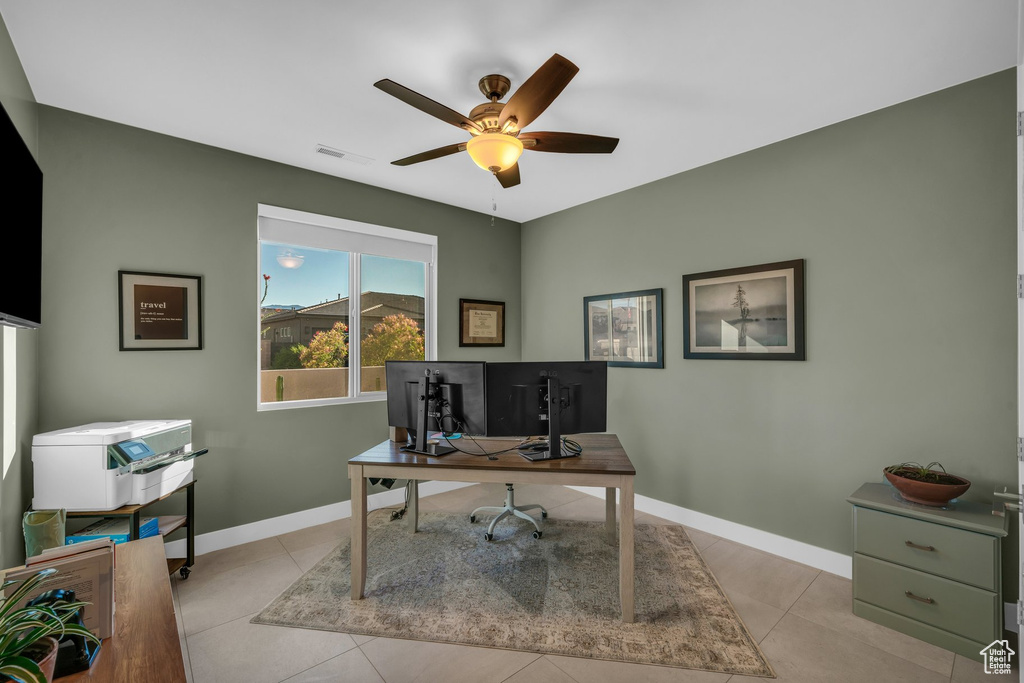 Office with a ceiling fan, baseboards, and light tile patterned flooring