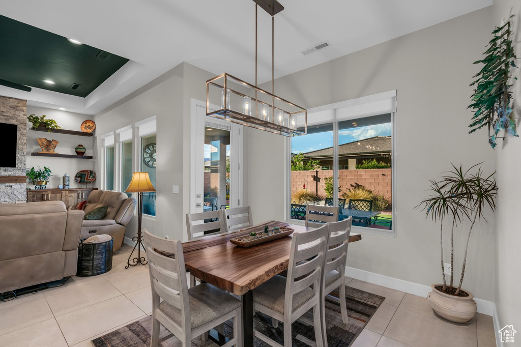 Dining space featuring light tile patterned floors, a chandelier, and baseboards