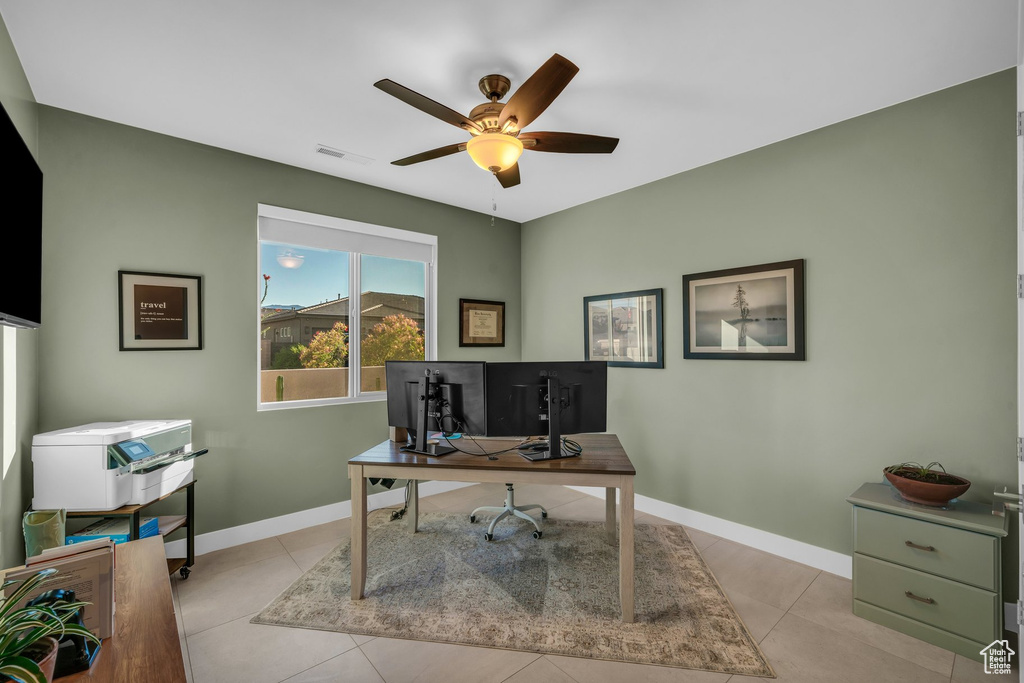 Office space with ceiling fan, baseboards, and light tile patterned flooring