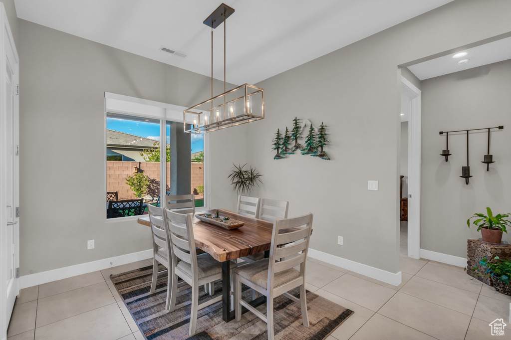 Dining space featuring a chandelier, baseboards, and light tile patterned floors