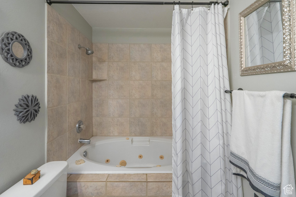 Full bath with a combined bath / shower with jetted tub and toilet