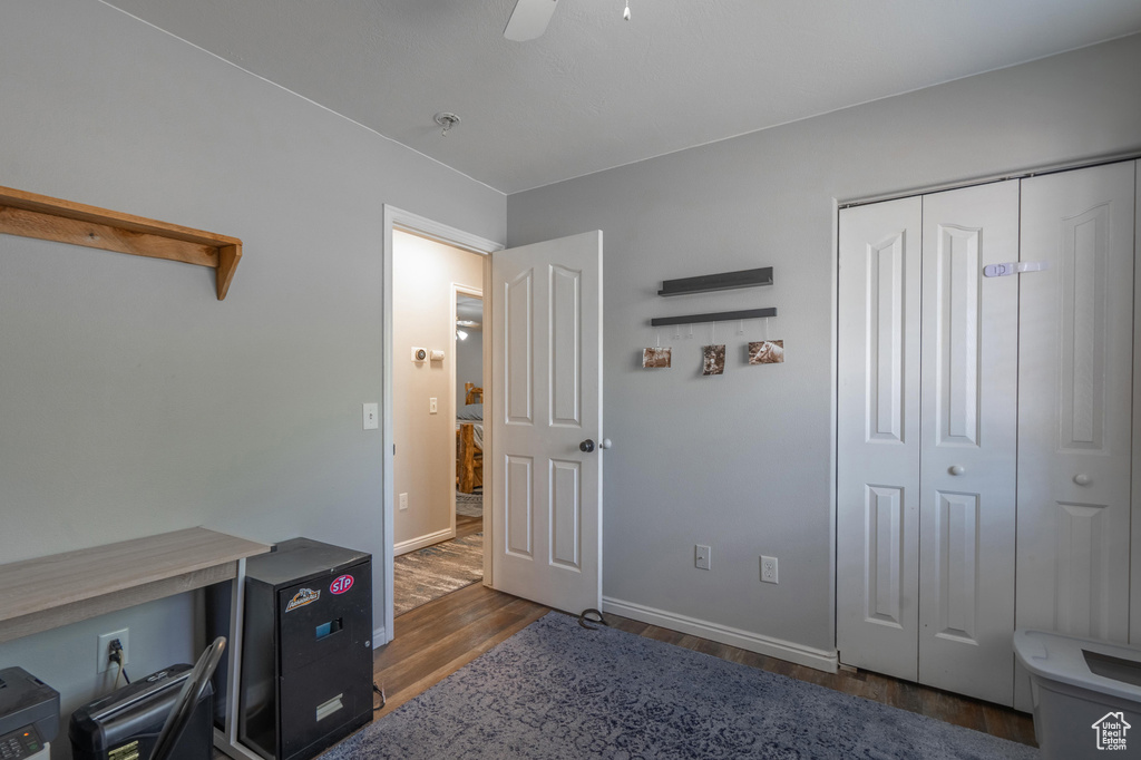 Bedroom featuring wood finished floors, baseboards, a closet, and a ceiling fan