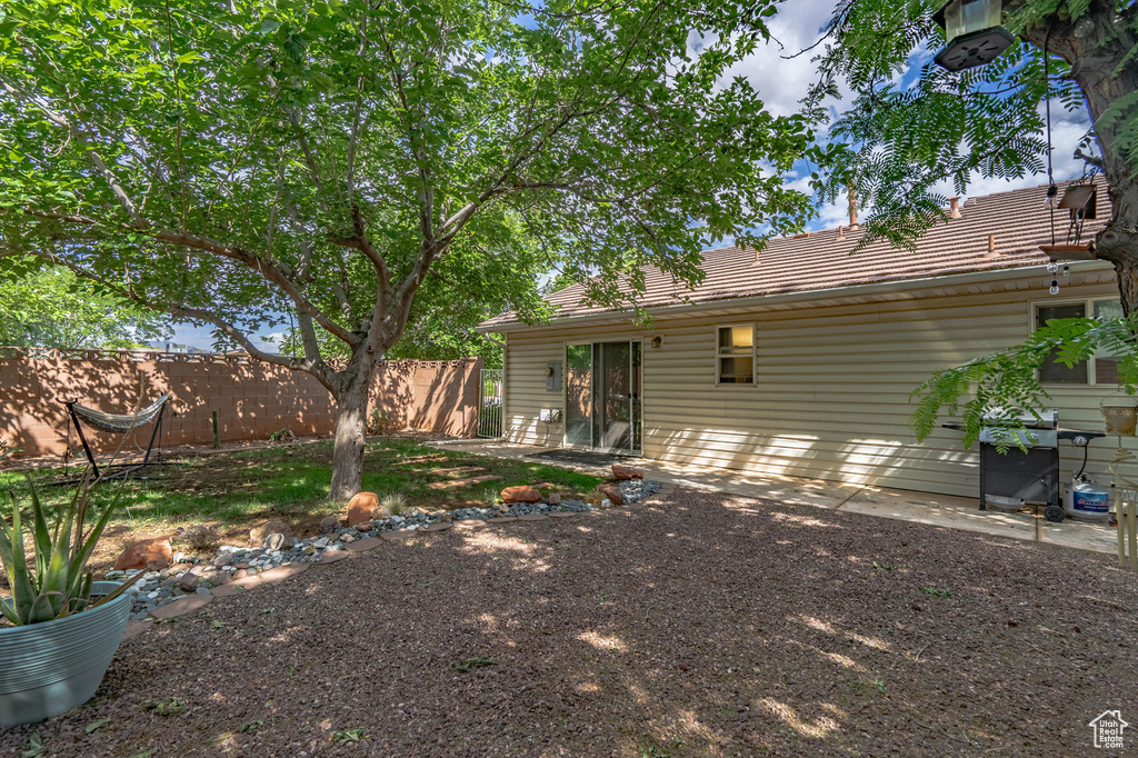 Back of house with fence and a tiled roof