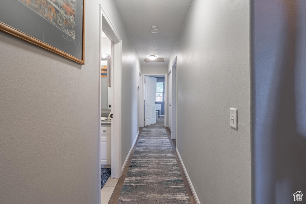 Hall with baseboards and wood finished floors