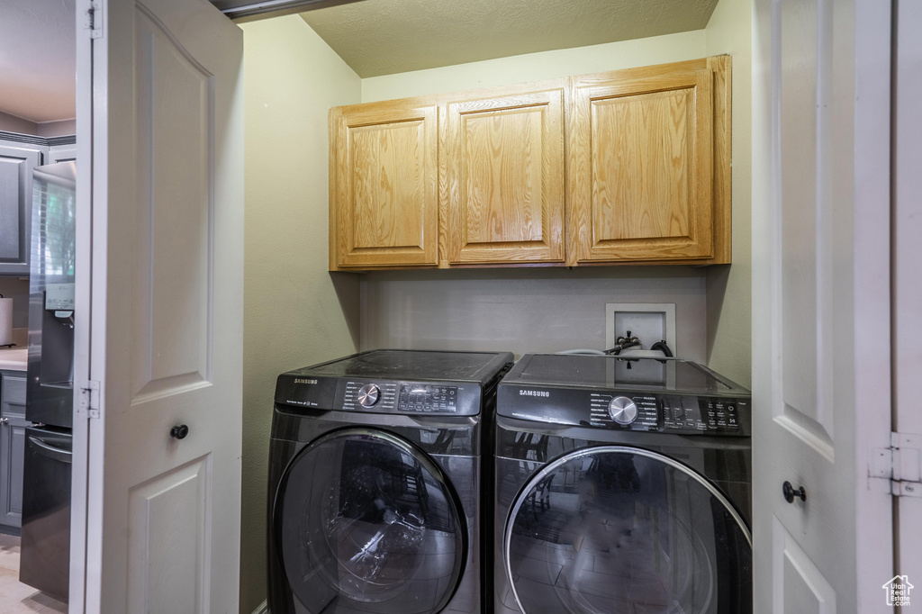 Laundry area with cabinet space and washing machine and clothes dryer