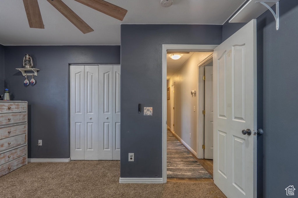 Carpeted bedroom featuring a closet, baseboards, and ceiling fan