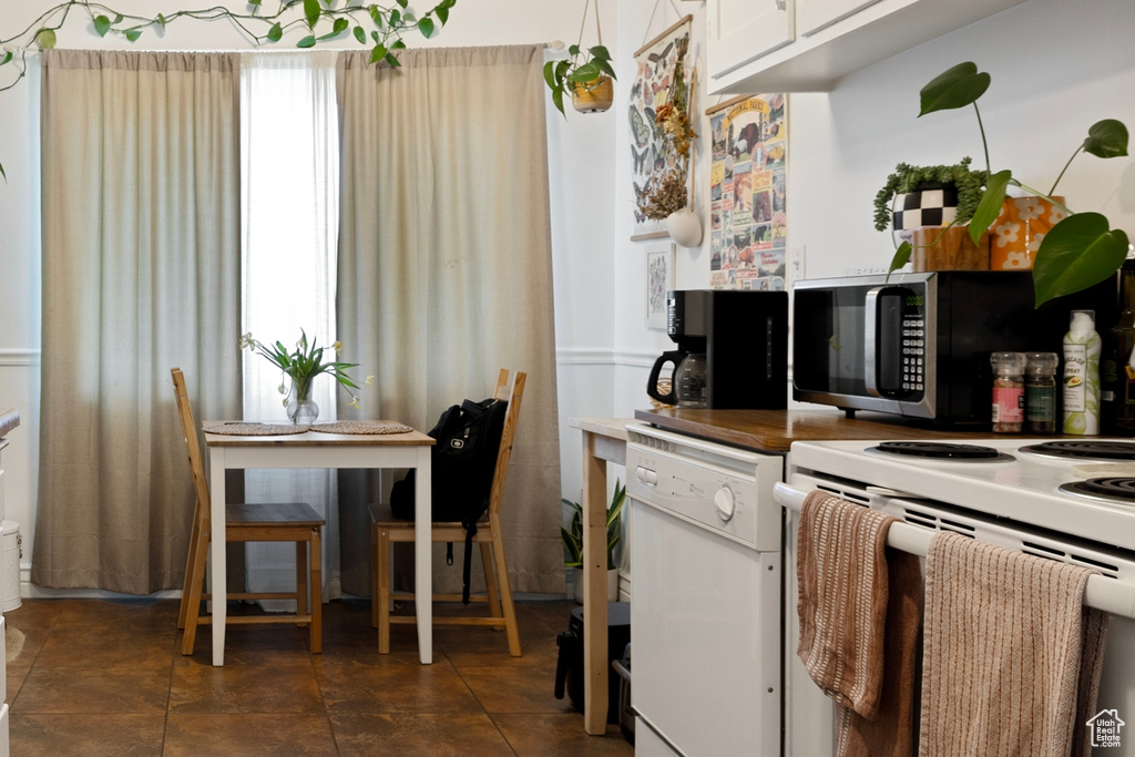 Kitchen featuring white appliances and white cabinets