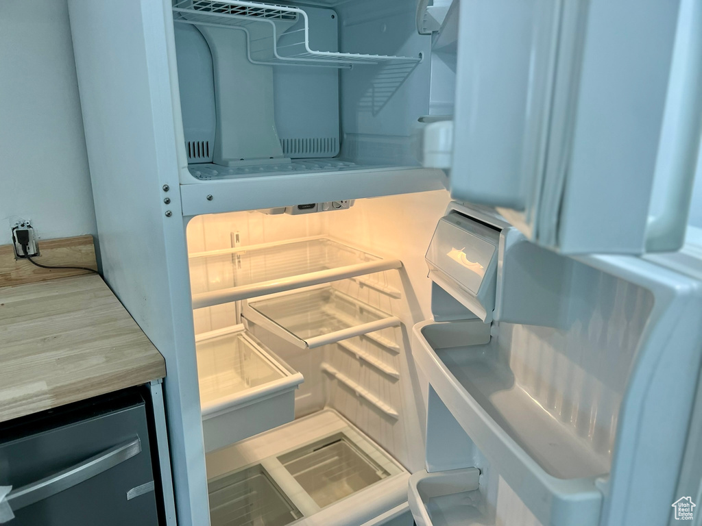 Kitchen view of refrigerator and light countertops