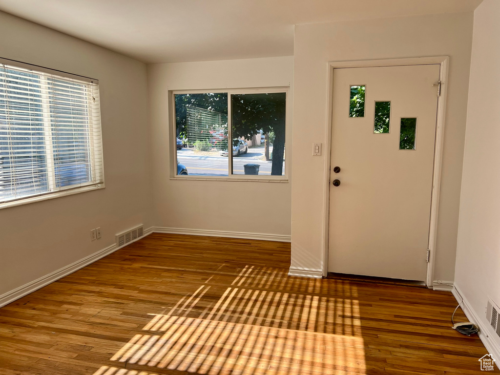 Foyer featuring healthy amount of natural light, wood finished floors, and baseboards