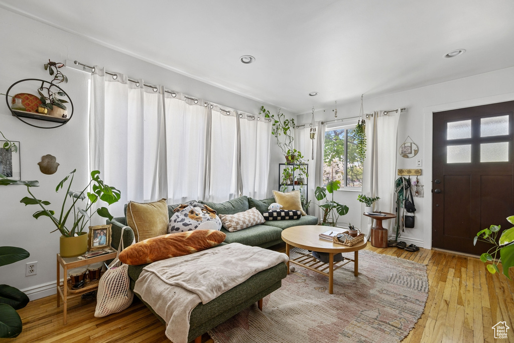 Living area with light wood-type flooring, baseboards, and recessed lighting