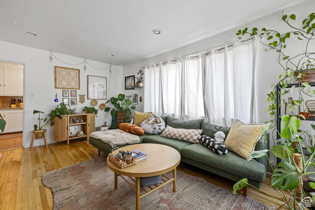 Living area with light wood-type flooring and recessed lighting
