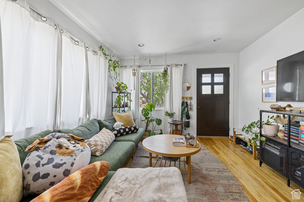 Living area with light wood-style flooring and recessed lighting