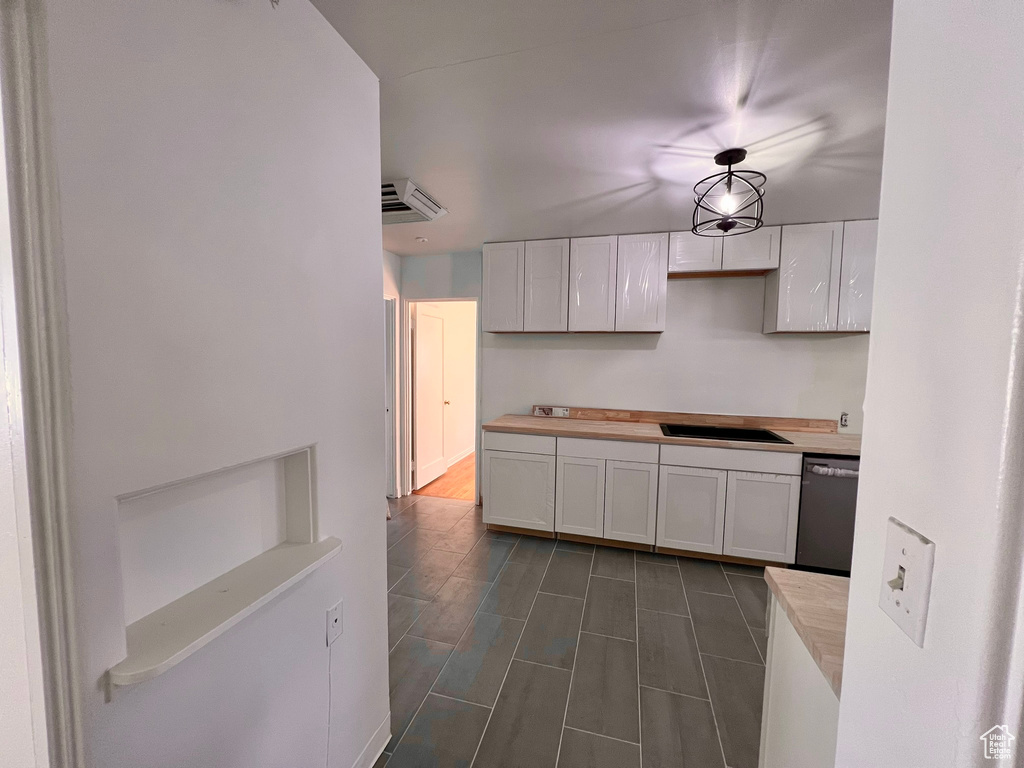 Kitchen with dishwasher, white cabinets, light countertops, and a sink